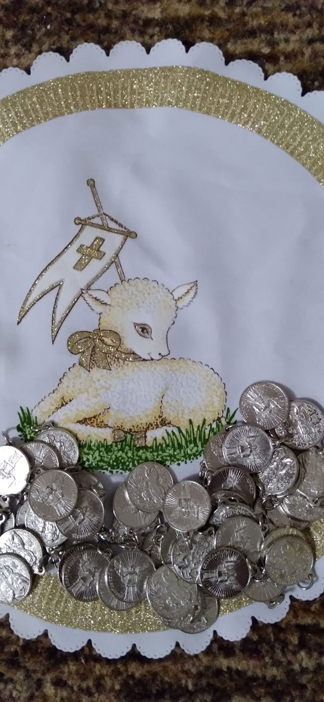 Easter-themed decorative fabric featuring a glittery gold arch and a sleeping lamb with a banner, surrounded by silver coins.