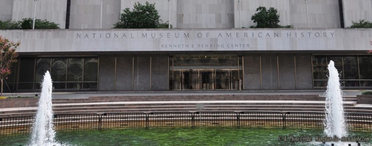 Facade of the National Museum of American History (Kenneth Behring Center) with steps and a two-jet fountain in front of a reflecting pool.